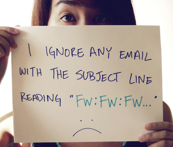 Woman holding a sign that reads "I ignore any email with the subject line reading "FW:FW:FW..."". Beneath the text is an unhappy face